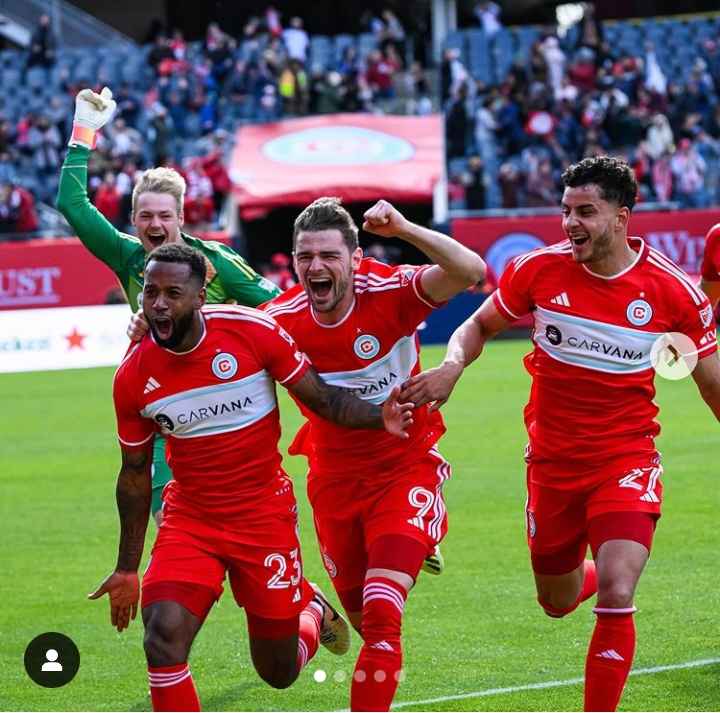 Image - Kellyn Acosta on the pitch celebrating a win with his teammates. 